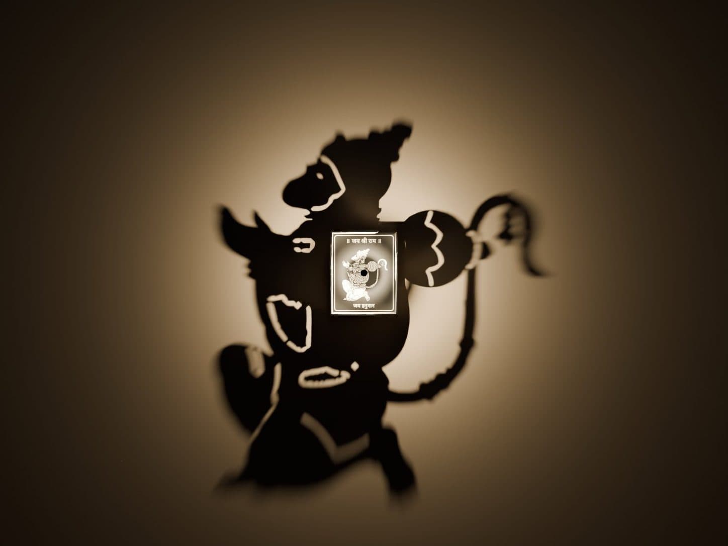 A Hanuman silhouette thrown across a wall by a small 3D-printed shadow lamp